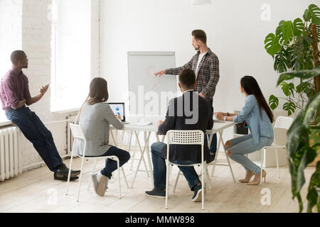 Grave imprenditore casual dando la presentazione per il lavoro dei dipendenti Foto Stock