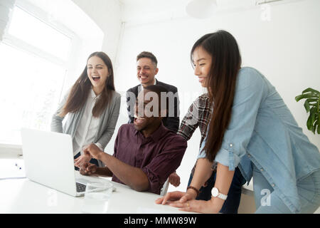 Felice friendly diversi team millenario ridere guardare online Foto Stock