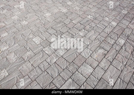 Pavimentazione di pietra in prospettiva. Pavimentazione in pietra texture. In ciottoli di granito pavimentazione in background. Sfondo astratto di un cobblestone pavement close-up, house Foto Stock