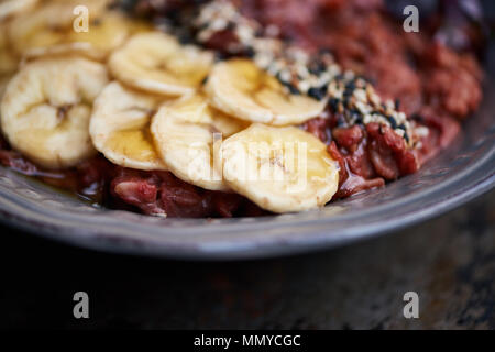 La colazione ciotola di barbabietole, banana e avena su un vassoio Foto Stock