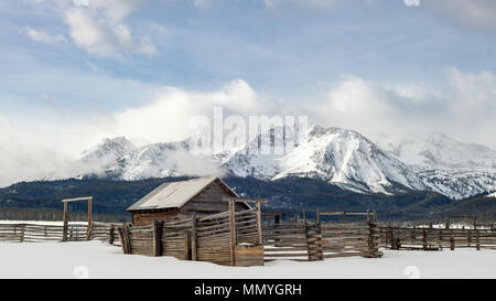 Western classico corral con log recinzione e coperta di neve la gamma della montagna Foto Stock