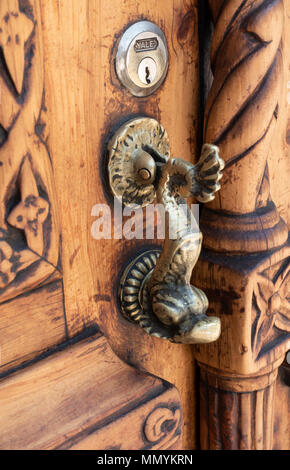 Ottone respingente della porta su un lato in legno intagliato porta in San Miguel De Allende, Messico Foto Stock