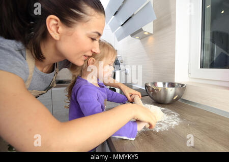 La Madre insegna la figlia per rendere l'impasto. I rapporti di famiglia tema. Foto Stock