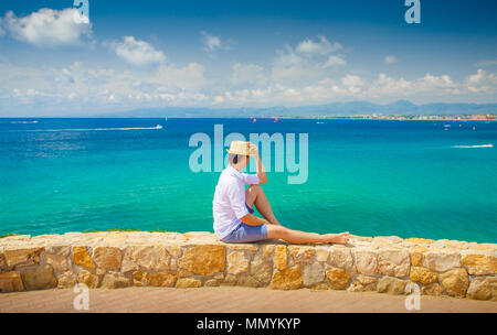 Salou resort. Costa Dorada Costa. Giovane uomo godendo estate vista mare. L'uomo sul blu del mare e cielo chiaro dello sfondo. Foto Stock