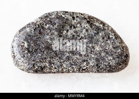 Le riprese in modalità macro di roccia naturale campione - burattati peridotiti pietra con phlogopite mica su marmo bianco sfondo dalla regione Kovdor, penisola di Kola Foto Stock