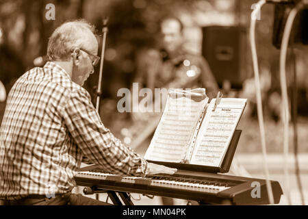 DIMITROVGRAD, Bulgaria - 30 Aprile 2018: note di jazz del cavalletto pianinst mettere sopra il suo pianoforte mentre il musicista è giocare in strada evento concerto ded Foto Stock