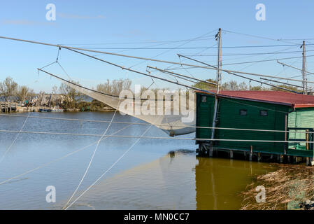 Tutina in rete di grandi dimensioni del vecchio tradizionale stilt Capanna di pesca sulla laguna, girato in primavera luminoso della luce del sole a Comacchio, Ferrara, Italia Foto Stock