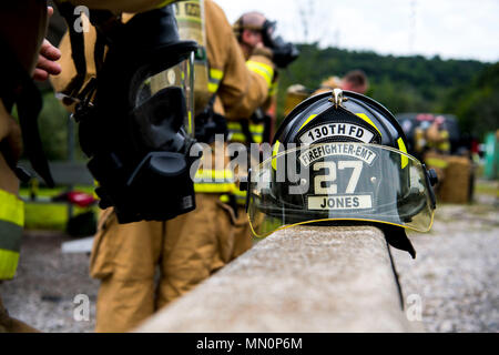 Stati Uniti Air Force Staff Sgt. Channing Jones, un vigile del fuoco per la 130Airlift Wing Fuoco e i servizi di emergenza, mette sulla sua maschera di aria come egli si prepara ad entrare in una simulazione di casa di fuoco il 6 agosto 2017, in preparazione alle situazioni di emergenza e centro di formazione, Istituto, W.Va. Un incendio rimuove ossigeno utilizzabile nell'aria ed emette il monossido di carbonio come risultato, dando ai vigili del fuoco meno aria respirabile che richiede che i vigili del fuoco di utilizzare autorespiratori ad aria compressa per completare i loro compiti. (U.S. Air National Guard Foto di Airman Caleb M. Vance) Foto Stock