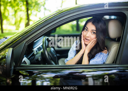 Distratti spavento volto di una donna alla guida di auto, ampia bocca aperta occhi holding lato ruota la visualizzazione della finestra. Negativo faccia umana emozione espressione di reazione. T Foto Stock