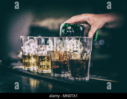 Barista rendendo cocktail, girato di alcol in vetro Foto Stock