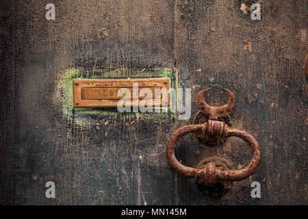 Legno marrone porta lo sfondo con il letterbox arrugginito e maniglia. Trito chiuso ingresso, vista ravvicinata con i dettagli. Foto Stock