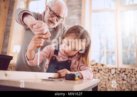 Smart bella ragazza con un cacciavite Foto Stock