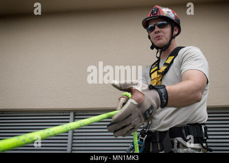 Tech. Sgt. Shawn Edgecomb, 374 Ingegneria Civile Squadron assistente capo della prevenzione degli incendi, mutandine partecipanti prima rappelling giù un edificio, 7 agosto 2017, a Yokota Air Base, Giappone. I vigili del fuoco di partecipare a questo tipo di formazione al fine di mantenere le competenze necessarie per rispondere alle emergenze incendio. (U.S. Air Force foto di Airman 1. Classe Juan Torres) Foto Stock