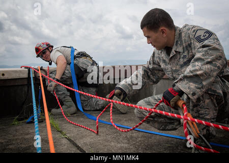 Avieri assegnato al 374 Ingegneria Civile Squadron assistere Col. John Winkler, 374 la missione del gruppo di supporto commander, rappel giù un edificio, 7 agosto 2017, a Yokota Air Base, Giappone. I vigili del fuoco di partecipare a questo tipo di formazione al fine di mantenere le competenze necessarie per rispondere alle emergenze incendio. (U.S. Air Force foto di Airman 1. Classe Juan Torres) Foto Stock