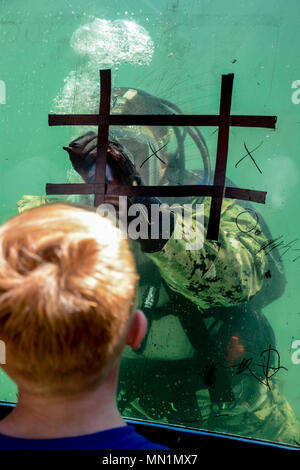 INDIANAPOLIS (Agosto 7, 2017) Navy Diver di terza classe Kolin Steele, assegnato a Mobile Diving e unità di soccorso (MDSU) 2 gioca un gioco di tic-tac-toe con un bambino mentre sommersa nella (EODGRU) 2 vasca di immersione a Indianapolis State Fair durante la settimana della marina di Indianapolis. Navy settimane la messa a fuoco di una varietà di beni, attrezzature e personale su una singola città per un week-end di una lunga serie di combattimenti progettato per portare l'America Navy più vicina alla gente che protegge, in città che non hanno una grande presenza navale. (U.S. Navy foto di artigliare il compagno del 2° classe Erin giovenco/rilasciato) Foto Stock