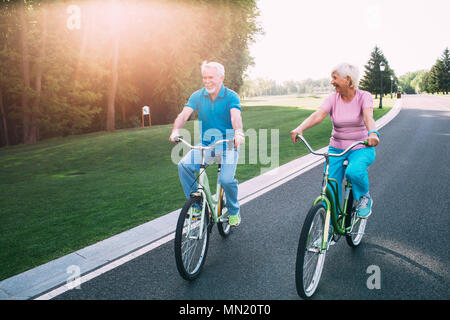 Coppia matura in bicicletta sul parco. anziani l uomo e la donna sono attivamente in appoggio, il pensionamento Foto Stock