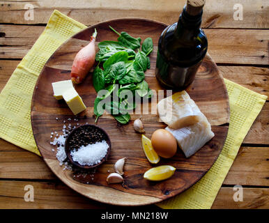 Pesci, spinaci e insalata di uova su uno sfondo scuro, vista dall'alto. Delizioso Cibo sano concetto Foto Stock