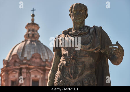 Roma, la statua in bronzo di imperatore Giulio Cesare e sullo sfondo la cupola dei Santi Luca e Martina Chiesa Foto Stock