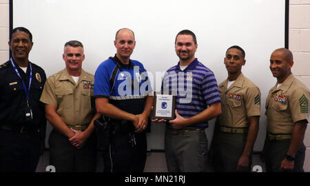 Master funzionario di polizia II Scott Johnson detiene la placca presentati al nuovo Berna Dipartimento di Polizia in apprezzamento per istruire un avanzato corso piloti in New Bern, N.C., e il Agosto 9, 2017. Marines assegnato al parafango Marine Communications Squadron 28 presentato il dipartimento con la placca per mostrare il loro apprezzamento per i funzionari che hanno istruito il corso. MWCS-28 è assegnato a aria marina gruppo di controllo 28, 2° velivolo marino ala. (U.S. Marine Corps photo by Lance Cpl. Justin Roux/ rilasciato) Foto Stock