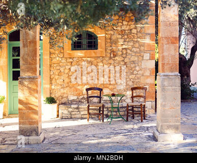 Vecchia casa portico e cortile con albero di olivo Foto Stock