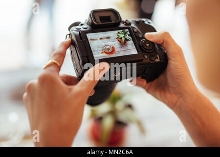 Close up di un blogger di scattare le foto di una teiera in vetro e un impianto che utilizza una telecamera professionale per il suo cibo blog. Blogger alimentare a scattare foto per lei Foto Stock