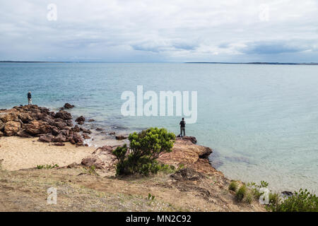 Due pescatori sulle rocce rosse al punto Erehwon Beach, Cowes, Phillip Island, Victoria, Australia Foto Stock