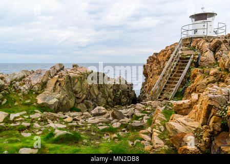 Western Kullaberg riserva naturale, Svezia - il piccolo faro bianco Kullen ovest alla fine di una scogliera costiere dal mare. Foto Stock