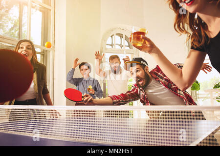 Gruppo di felice giovani amici giocando tavolo da ping pong Campo da tennis Foto Stock