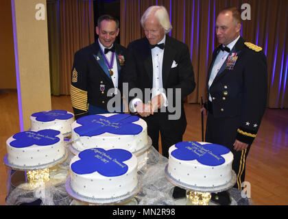 Comandante generale della 88 di sostegno regionale magg. di comando Gen. Patrick Reinert, destra e 88th comando RSC Sgt. Il Mag. Earl Rocca lungo con l'autore e imprenditore Robert Edsel, centro, condurre una torta cerimonia del taglio durante un 88th RSC sede e sede della società in banchetti Warrens, Wis. del 19 agosto, in onore del 100° Anniversario dell istituzione della 88ª divisione. Foto Stock