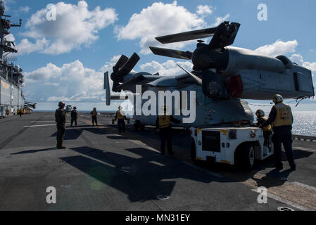 170825-N-NB544-033 CORAL SEA (Agosto 25, 2017) Aviation Boatswain Compagni (manipolazione) utilizzare un come32/A-39 a bordo trattore di traino per spostare una MV-22B Osprey, assegnato al 'Dragons' del mezzo marino Tiltrotor Squadron (VMM) 265 (rinforzato), sul ponte di volo dell'assalto anfibio nave USS Bonhomme Richard (LHD 6). Bonhomme Richard, ammiraglia del Bonhomme Richard Expeditionary Strike gruppo, è operativo in Indo-Asia regione del Pacifico per rafforzare le partnership e di essere una pronta risposta in vigore per qualsiasi tipo di emergenza. (U.S. Foto di Marina di Massa lo specialista di comunicazione 2a classe Kyle Carlstrom/rele Foto Stock