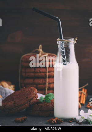 Piena bottiglia di vetro con il latte e un nero di paglia, tonificazione vintage Foto Stock