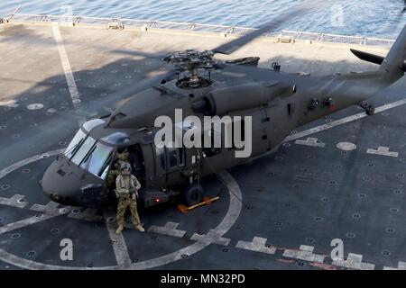 I soldati assegnati a Bravo e sede società, 1° Brigata, 147th Air Assault elicottero Battaglione, e il 2° Brigata, 149a di supporto generale del battaglione di aviazione, entrambi assegnati per la ventinovesima combattere la Brigata Aerea, condurre un mazzo di qualificazione di atterraggio con un UH-60 Blackhawk sulla US Naval Ship Alan Shepard, 9 agosto, nel Golfo Arabico. I soldati devono completare almeno 10 deck sbarchi ogni mese per mantenere il loro status di qualificazione. (U.S. Foto dell'esercito da Staff Sgt. Jeremy Miller/rilasciato) Foto Stock