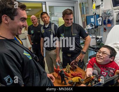 170817-N-RM689-196 CHICAGO (Agosto 17, 2017) membri dell'U.S. Navy parachute team, il salto delle rane, condividere una risata con un giovane ventola durante una visita alla Ann & Robert H. Lurie ospedale per bambini di Chicago. Il salto delle rane sono basati in San Diego e antenna di eseguire dimostrazioni di paracadute intorno alla nazione a sostegno del Naval Special Warfare Marina e del reclutamento del personale. (U.S. Foto di Marina di Massa lo specialista di comunicazione di terza classe Kelsey L. Adams/rilasciato) Foto Stock