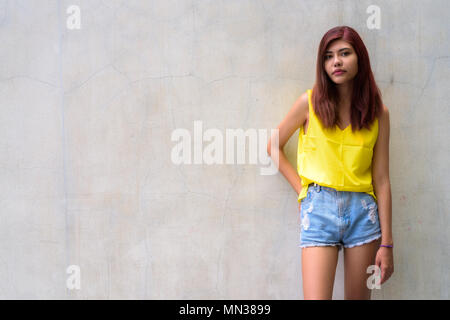 Bella ragazza adolescente indossando vibrante maglietta gialla Foto Stock