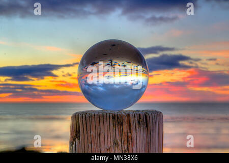 Tramonto attraverso la lensball sulla spiaggia Bellbuoy dopo wild meteo Foto Stock