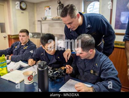 170822-N-VR594-0044 GOLFO ARABICO (Agosto 22, 2017) Lt. Ryan Dishman illustra i componenti di un sestante per i marinai durante la navigazione astronomica della formazione a bordo della Ticonderoga-class guidato-missili cruiser USS Princeton (CG 59). Princeton è distribuito negli Stati Uniti Quinta Flotta area di operazioni a sostegno della sicurezza marittima operazioni destinate a rassicurare gli alleati e partner e preservare la libertà di navigazione e il libero flusso di commercio nella regione. (U.S. Foto di Marina di Massa lo specialista di comunicazione di terza classe Kelsey J. Hockenberger/rilasciato) Foto Stock