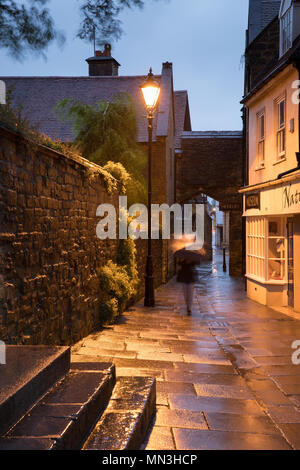 Donna sotto la pioggia in una serata estiva, Sherborne, Dorset, England, Regno Unito Foto Stock