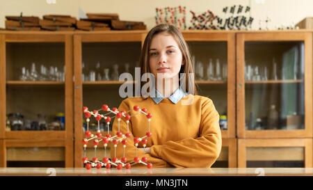 Ritratto di giovane donna studente di college in chimica classe. Studente focalizzato in aula. Autentico concetto di istruzione. Foto Stock