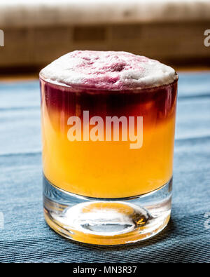 New York Sour Cocktail con schiuma e backround blu. Concetto di bevanda. Foto Stock