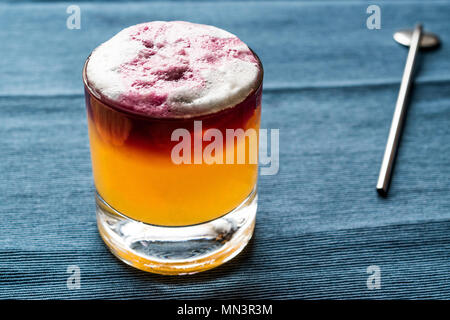 New York Sour Cocktail con schiuma e backround blu. Concetto di bevanda. Foto Stock