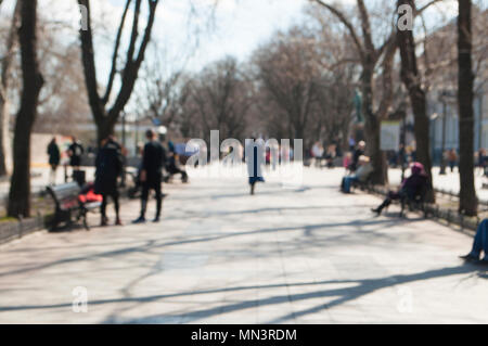 Immagine sfuocata delle persone che camminano in una giornata di sole. Foto Stock