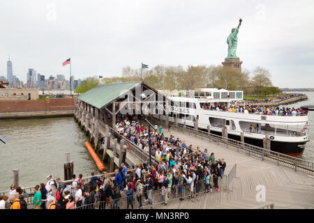 I turisti di salire a bordo di una nave da crociera al molo a Liberty Island, con la Statua della Libertà, Liberty Island, New York City, Stati Uniti d'America Foto Stock