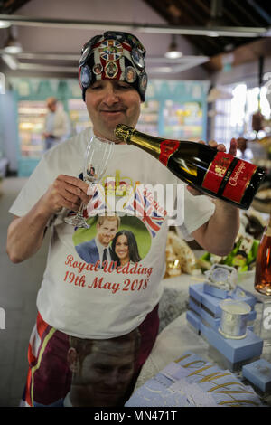 Windsor, Regno Unito. 14 maggio 2018. Royal fan John Loughrey, 63, da Streatham, finge di versare una bottiglia di Buckingham Palace lo Champagne in Windsor Farm Shop davanti al Royal Wedding. Credito: amanda rose/Alamy Live News Foto Stock