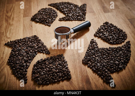 I chicchi di caffè formando simbolo di riciclaggio intorno a motivi espresso in portafilter Foto Stock