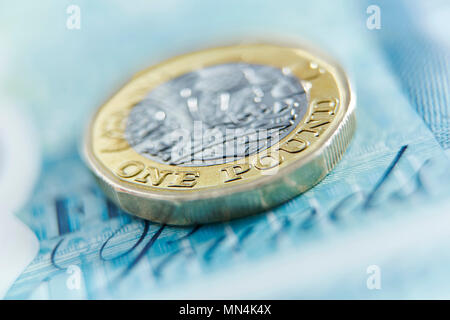 Chiudere fino a una libbra moneta su cinque pound nota Foto Stock