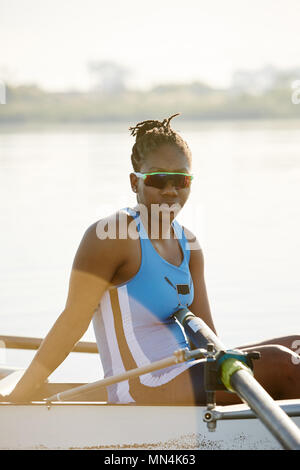 Ritratto femminile fiducioso vogatore in scull sul lago Foto Stock