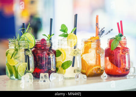 Varie limonate in vasetti di vetro con orange lime otange limone fragole e frutta fresca frutta. Foto Stock