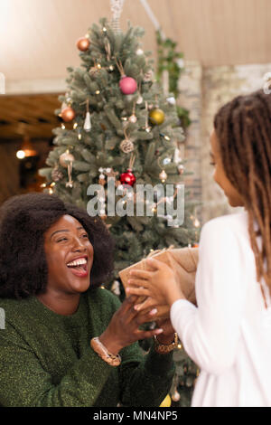 Madre entusiasta di dare un regalo di Natale per la figlia Foto Stock