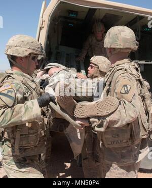 Campo carico medics un incidente in un campo per lettiera ambulanza per essere trasportato al rullo 2 centro di triage durante l'esercizio MASCAL su McGregor addestramento complesso, Nuovo Messico, 4 maggio. La formazione è stata parte della Multi-Echelon Brigata integrata alla formazione che la 155ABCT è attualmente in fase di preparazione per la sua distribuzione futuri a sostegno del funzionamento Spartan scudo. Foto Stock