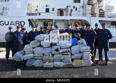 Guardacoste ferma il suo equipaggio stare accanto a circa 1 tonnellata di marijuana per un valore stimato di $ 2,2 milioni di valore all'ingrosso, a San Pietroburgo, Florida, Martedì, 8 maggio 2018. L'equipaggio a bordo della 210-piede Reliance-class cutter, homeported a San Pietroburgo, scaricate la droga dopo interdicting due sospetti di contrabbando di droga le navi e la detenzione di sette sospetti trafficanti di droga nel Mar dei Caraibi con l'assistenza doganale e di Pattuglia di Confine come parte del funzionamento Riptide. (U.S. Coast Guard foto di Sottufficiali di seconda classe Ashley J. Johnson) Foto Stock